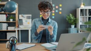 happy professional woman engaging with smartphone in office
