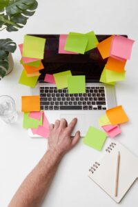 a person touching a touch pad of laptop with sticky notes